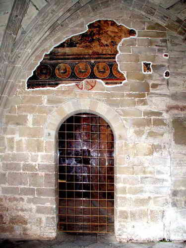 ACCESO AL TEMPLO DESDE LA CAPILLA DE SAN VICTORIAN. RESTOS PICTÓRICOS Y CRISMÓN